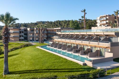 un complejo con piscina y palmeras en Kresten Palace Hotel, en Kallithea Rhodes