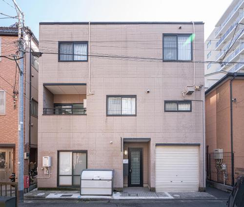um grande edifício de tijolos com garagem em ZAITO Tokyo Luna Lane Inn 菊川駅から徒歩5分 em Tóquio