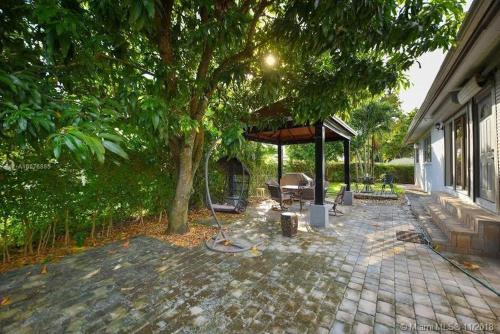 a gazebo with a chair under a tree at Modern Miami Oversized 3 Bedroom in Central Location in Miami