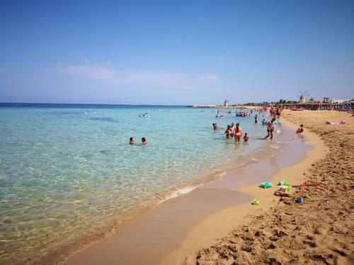 a group of people in the water at a beach at Historico Loft & Rooms Palazzo Adragna XIX in Trapani