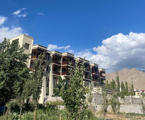 an apartment building with a mountain in the background at Hotel Rewa Ladakh in Leh