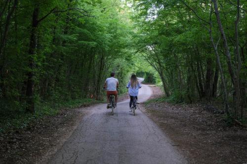 a couple of people riding bikes down a dirt road at VILLA PORTUM - Serenity, Nature, Heated Pool, FAMILY ONLY in VeliGolji