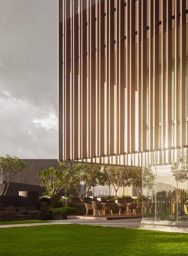 a building with tables and chairs in front of a building at Amari SPICE Penang in Bayan Lepas