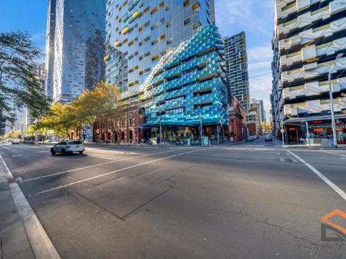 a car driving down a city street with tall buildings at Sakura Apartment in Melbourne