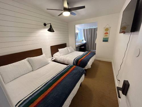 a bedroom with two beds and a ceiling fan at Sierra Motor Lodge - A Sierra Blue Hotel in Mojave