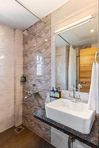 a bathroom with a white sink and a mirror at Mayur Retreat & Spa in Lonavala
