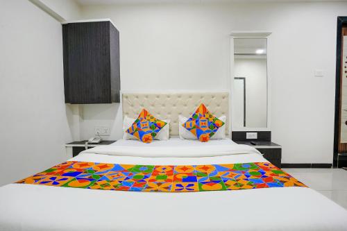 1 dormitorio con 1 cama grande con una manta colorida en FabExpress Rajmahal en Navi Mumbai