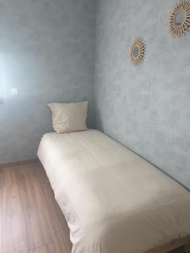 a white bed in a room with two mirrors on the wall at LE REFUGE in Lurcy-Lévis