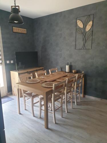 a dining room with a wooden table and chairs at LE REFUGE in Lurcy-Lévis