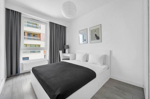 biała sypialnia z łóżkiem i 2 oknami w obiekcie Kolska Grey Apartment w Warszawie