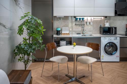 a kitchen with a table and chairs and a washing machine at Busan Station BOOKING THE BAY in Busan