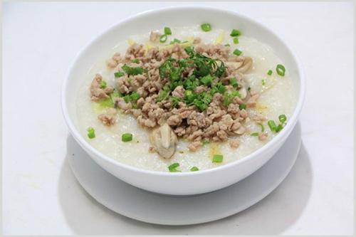 una ciotola bianca di zuppa con carne e cipolle verdi di Coffee Pacific Grand World Phú Quốc a Phu Quoc