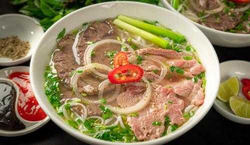 a bowl of soup with meat and onions and celery at Coffee Pacific Grand World Phú Quốc in Phu Quoc