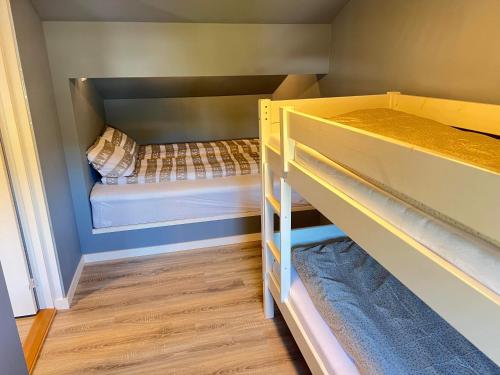 a small room with two bunk beds in it at Puntsnes Apartmen in Hjelmeland