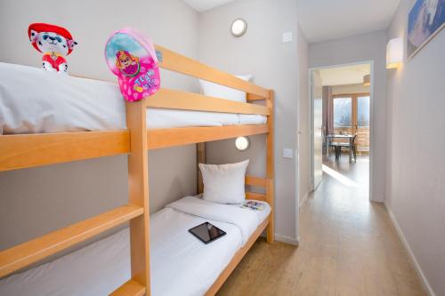 a room with two bunk beds and a hallway at SOWELL RESIDENCES Pra Loup in Pra-Loup