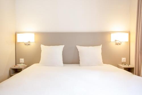 a bedroom with a large bed with white pillows at SOWELL RESIDENCES Pra Loup in Pra-Loup