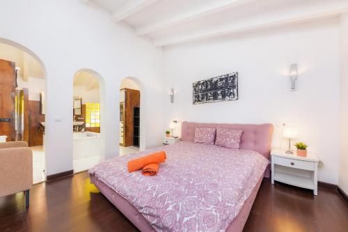 a bedroom with a bed with an orange pillow on it at Casa Varna in Capdepera