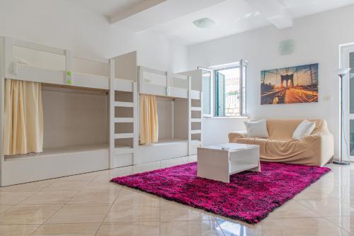 a living room with bunk beds and a pink rug at Love Dubrovnik Hostel in Dubrovnik