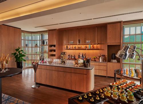 a large kitchen with wooden cabinets and a bar at Amari SPICE Penang in Bayan Lepas