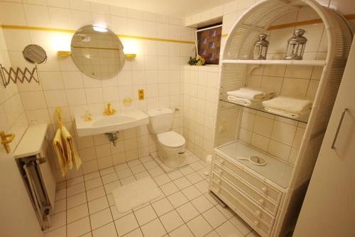 La salle de bains blanche est pourvue d'un lavabo et de toilettes. dans l'établissement 4-Jahreszeiten-Idylle Ollsen, à Hanstedt