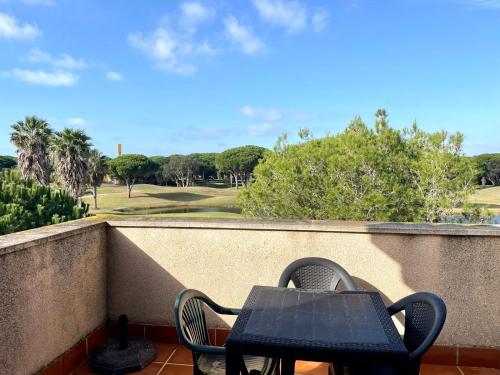 d'une table et de chaises sur un balcon avec un parcours de golf. dans l'établissement Apartamento Campo de Golf, à Chiclana de la Frontera