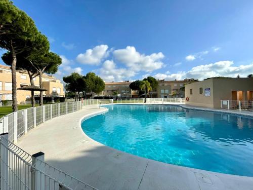 une grande piscine entourée d'une clôture. dans l'établissement Apartamento Campo de Golf, à Chiclana de la Frontera