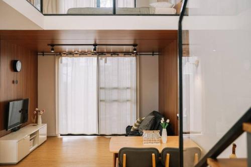 a living room with a table and a bed at Little Duck Villa - Tiny House near Gedong Putih in Lembang