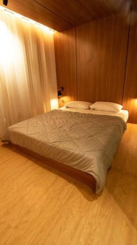 a bedroom with a large bed with a wooden wall at Little Duck Villa - Tiny House near Gedong Putih in Lembang