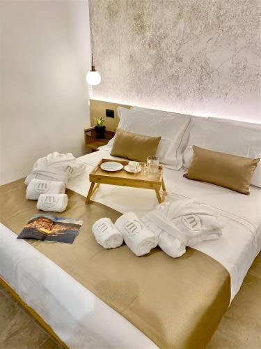 a bed with towels and a table on it at Meravigghia Suites Cefalù in Cefalù