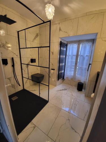 uma casa de banho com um WC e uma parede de vidro em LA MAISON 1788 em Meymac