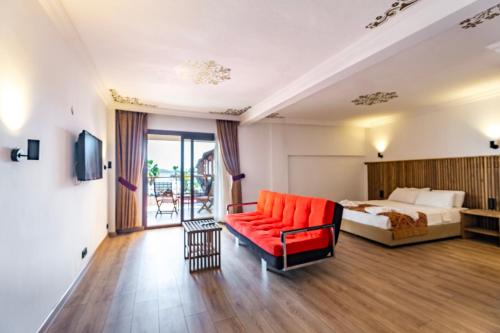 Costa Bitezhan Hotel - All Inclusive في بيتيس: غرفه فندقيه بسرير واريكه