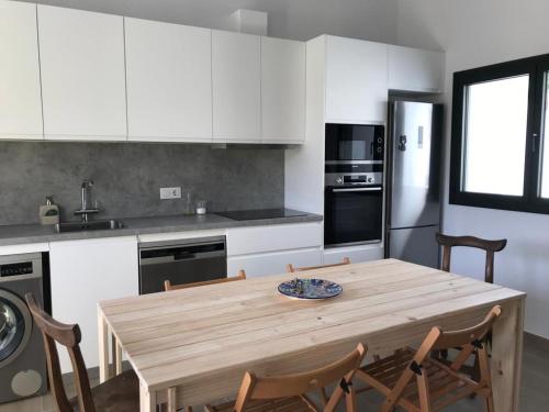 a kitchen with a wooden table and chairs in it at Encantadora casa rural Can Vidal in Espolla