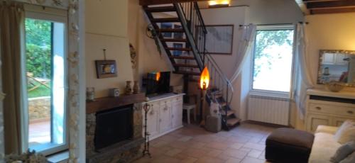 a living room with a fireplace and a spiral staircase at Casa vacanze Luna in Portovenere