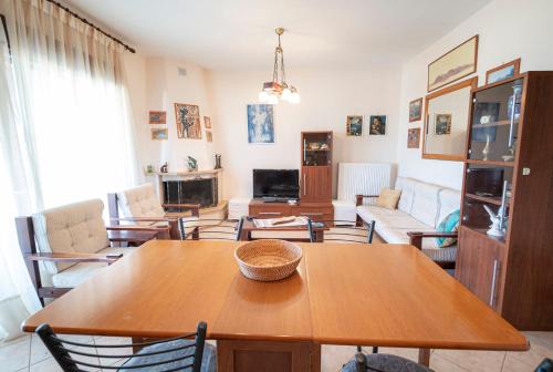 sala de estar con mesa de madera y sillas en Zela Seaview Maisonette by RentalsPro - Kalyves Halkidiki, en Kalivia Poligirou