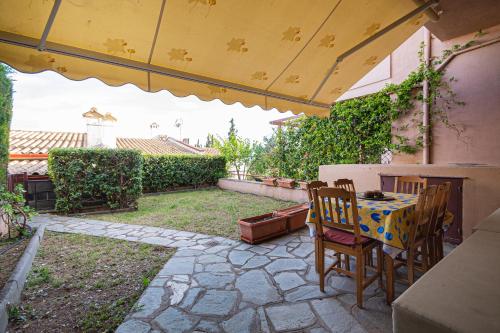 un patio con mesa y sillas en un patio trasero en Zela Seaview Maisonette by RentalsPro - Kalyves Halkidiki, en Kalivia Poligirou