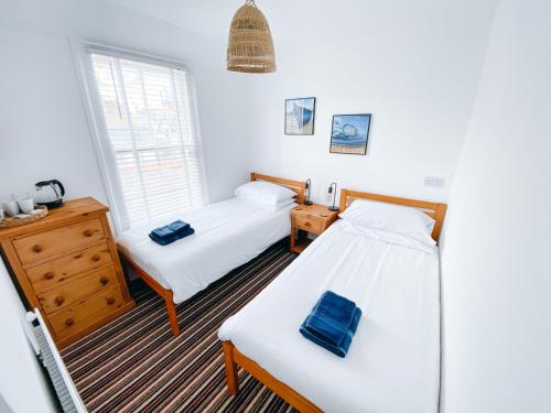 a bedroom with two beds and a window at Beachside Guesthouse in St Ives