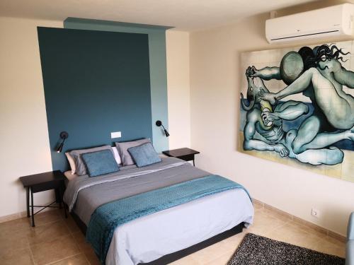 a bedroom with a bed with a painting on the wall at Casa Camé in São Bartolomeu de Messines