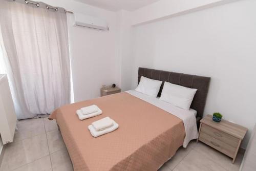 a bedroom with a large bed with two towels on it at Lovely 2-bedroom apartment with a city view (F10) in Piraeus