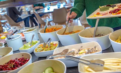 a table full of bowls of food with spoons at SOWELL RESIDENCES Pra Loup in Pra-Loup
