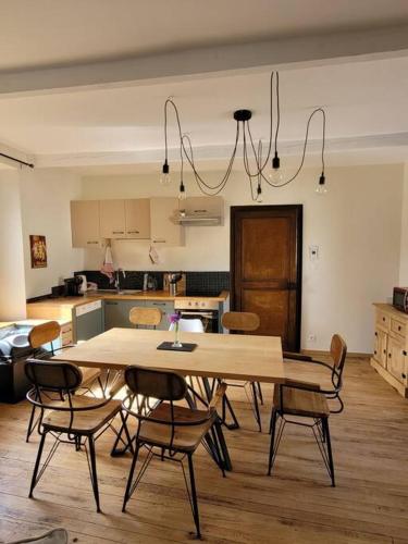 une cuisine avec une table et des chaises dans une pièce dans l'établissement Maison de village rénovée, à Metz