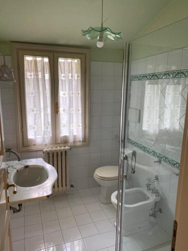 łazienka z 2 umywalkami, toaletą i prysznicem w obiekcie Casa di totto w mieście San Giovanni Di Baiano