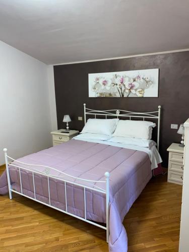 sypialnia z dużym łóżkiem z fioletową narzutą w obiekcie Casa di totto w mieście San Giovanni Di Baiano