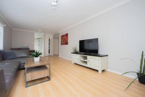 a living room with a couch and a flat screen tv at Room in Shared Apartment U1M in Brisbane