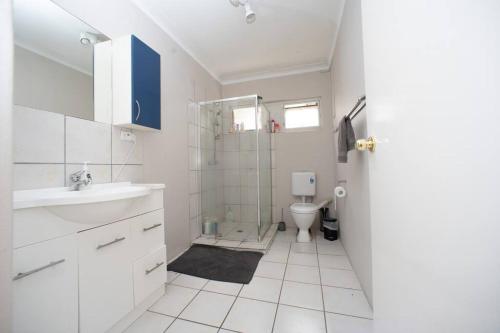 a white bathroom with a shower and a toilet at Room in Shared Apartment U1M in Brisbane