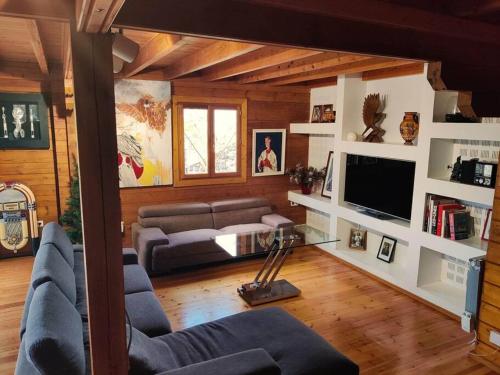 a living room with a couch and a tv at Le Chalet des Cévennes in La Plaine des Cafres