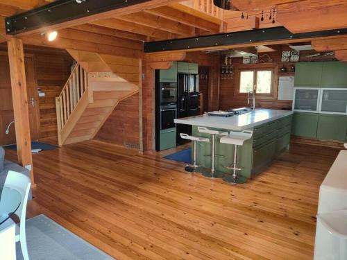 a kitchen with wooden floors and a staircase in a cabin at Le Chalet des Cévennes in La Plaine des Cafres