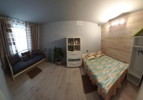 a bedroom with a bed and a couch in it at Hostel CION in Gliwice