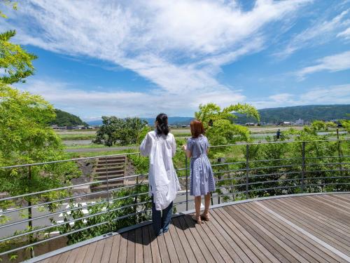 two women standing on a bridge looking out at a field at Fugaku Hanabusa in Izunokuni