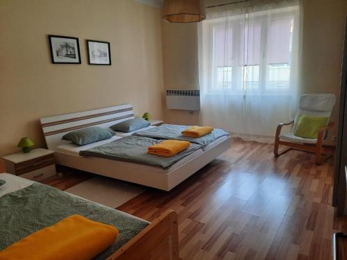 a bedroom with a bed and a chair and a window at Apartman Soda in Ogulin