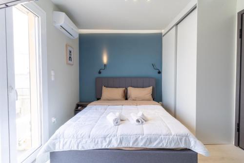 a bedroom with a large bed with two towels on it at Aiolos loft sea view peiraiki in Piraeus